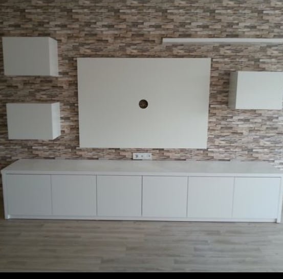Taş duvar önüne beyaz TV ünitesi