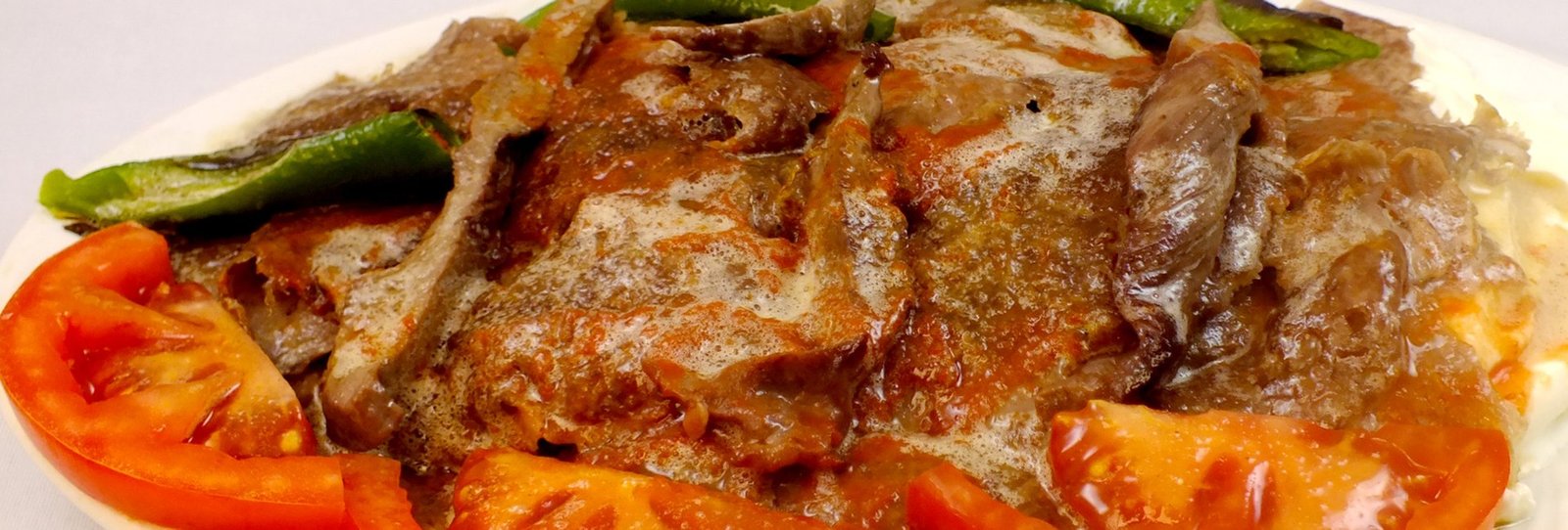 Tereyağlı domates sosuyla servis edilen Bursa Kebabı tabağı