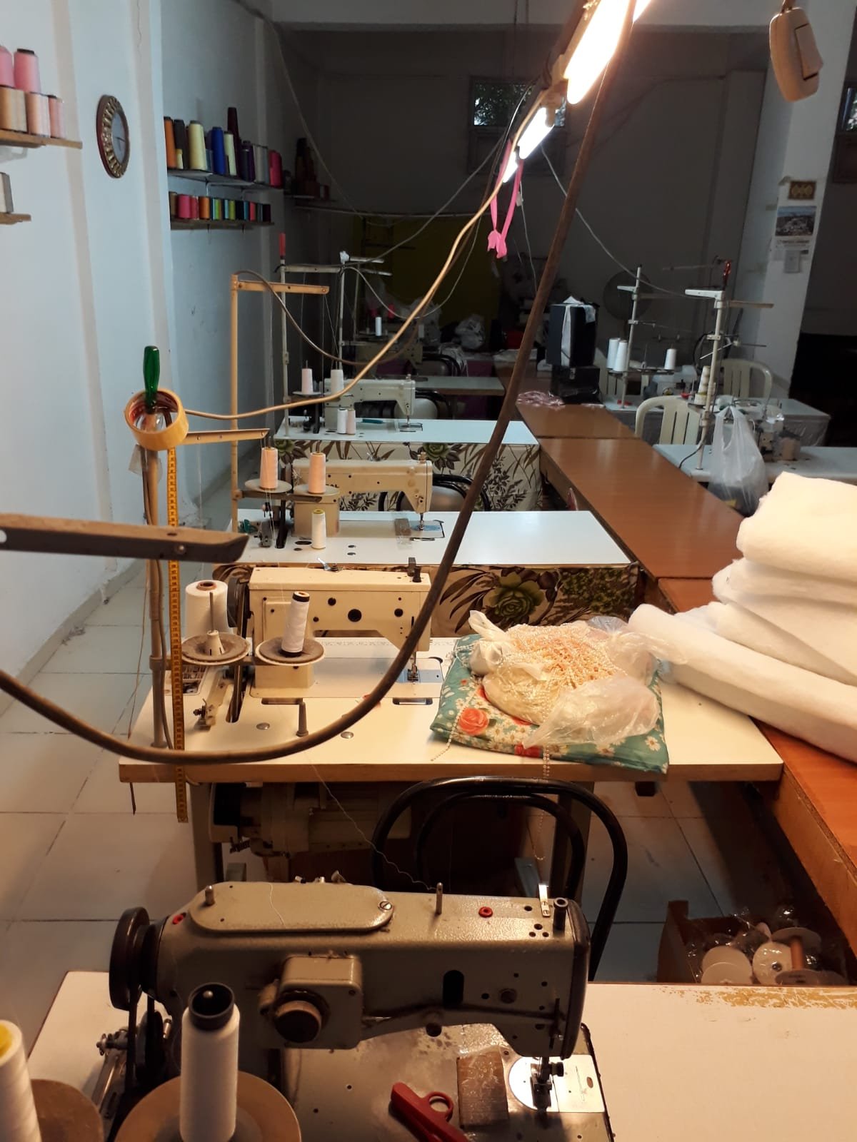 Dikiş makinesi ve hazırlanan kumaş toplarıyla üretim istasyonu