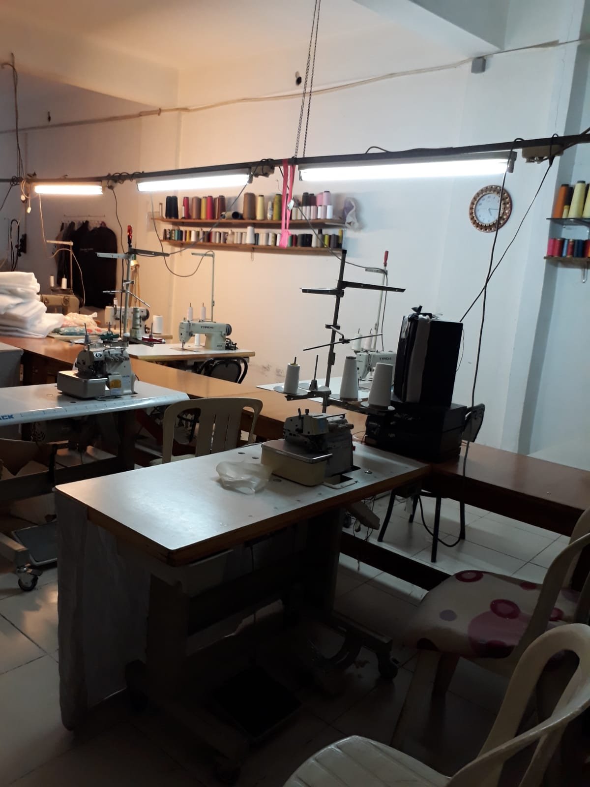 Atölyede iplik rafı ve dikiş makinesi hattı