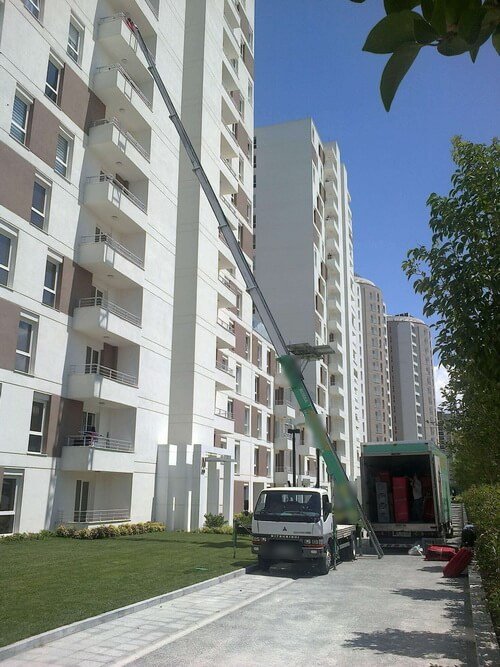 Modern bir sitede yüksek kata kurulmuş mobil asansörle taşıma
