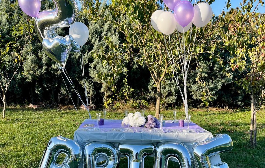 Bahçede balonlarla yıldönümü masası kurulumu